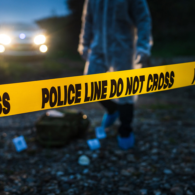 Forensic police investigator collecting evidence at the crime sc